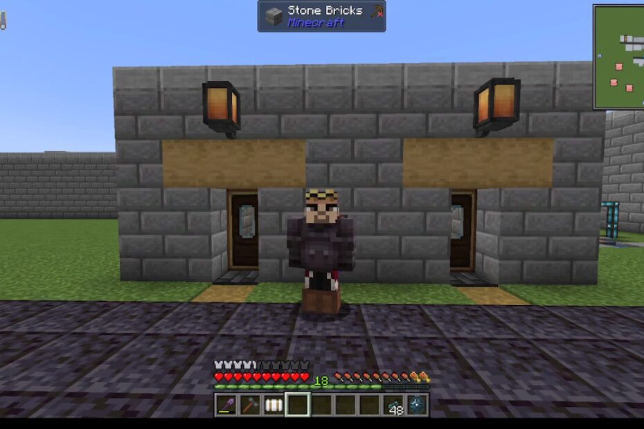 Minecraft screenshot: a player in dark armor stands between two wooden doors in a gray stone-brick building, with lanterns and a paved path.