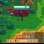 Player character stands in a lush green farm, beside a pink wagon with a green roof pulled by a purple animal; trees, fence, and a riverside dock visible, with the tool bar UI at the bottom.